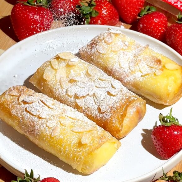 Strawberry cheesecake rice paper rolls with sliced almonds and icing sugar on top