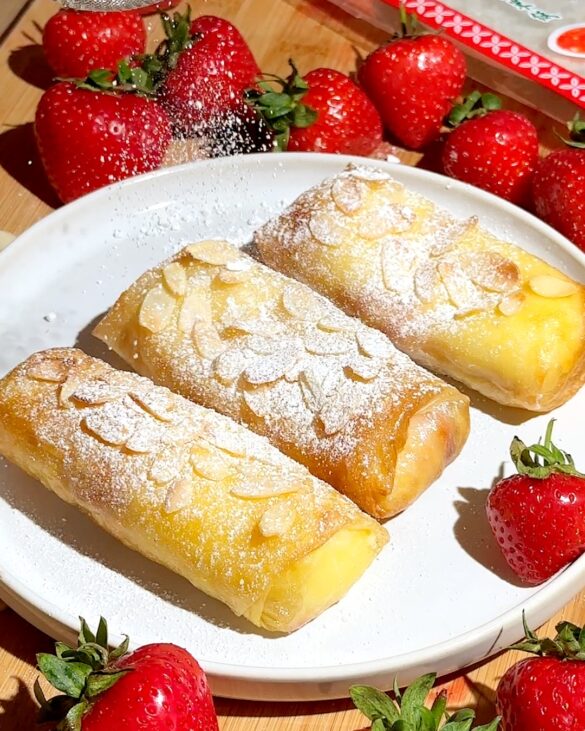 Strawberry cheesecake rice paper rolls with sliced almonds and icing sugar on top